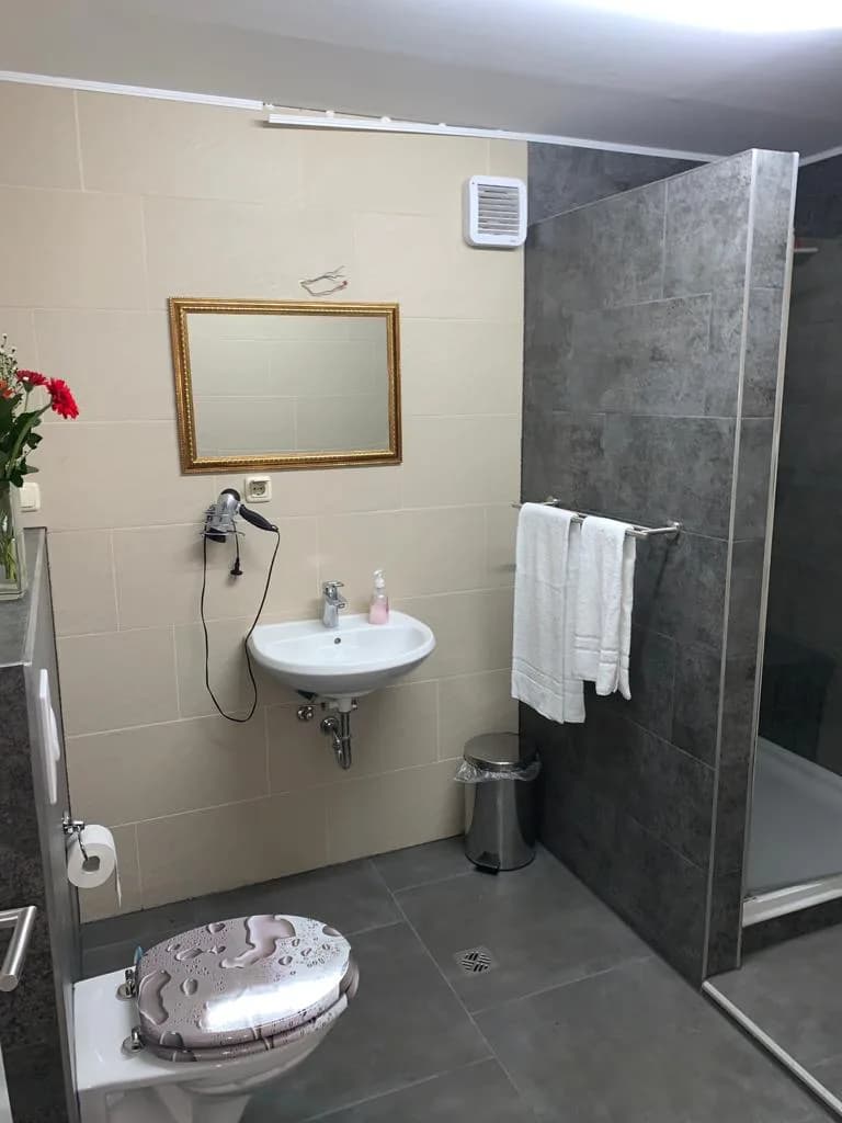 Sauberes Bad mit Dusche, Waschbecken und Handtüchern
