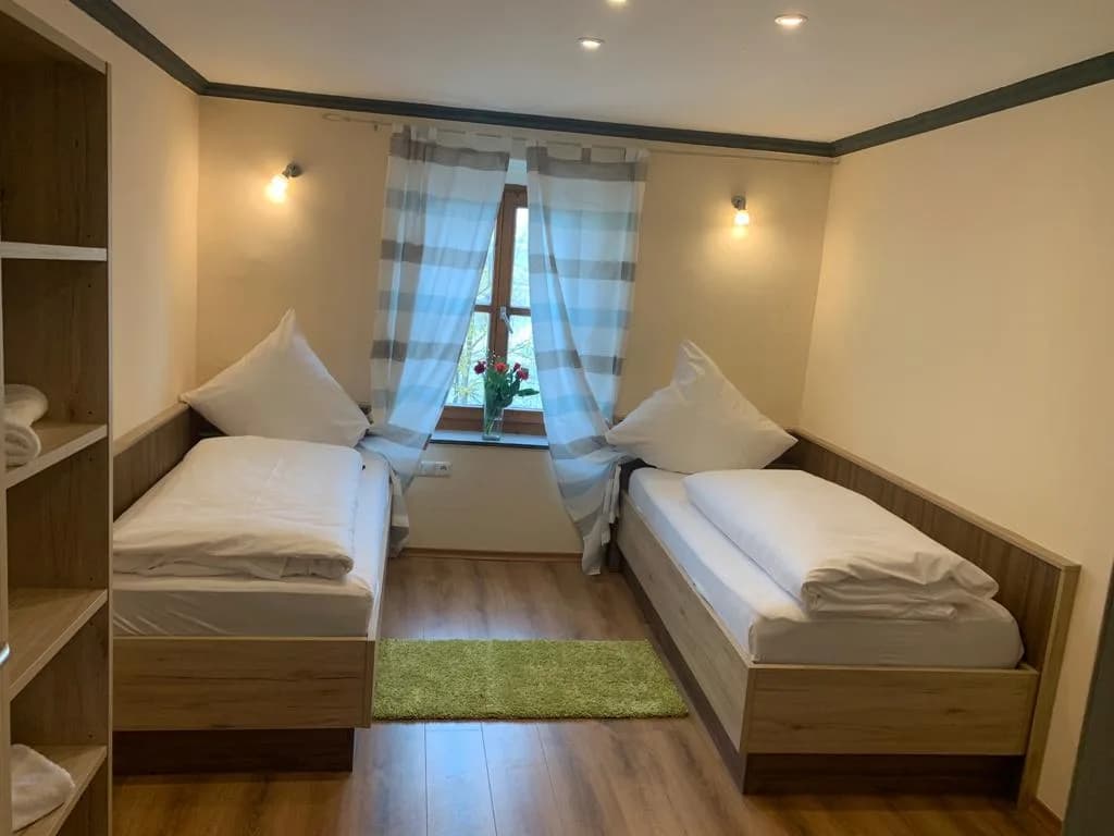Zimmer mit zwei Einzelbetten und Fenster