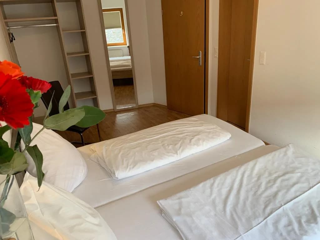 Einladendes Zimmer mit Bett, Kleiderschrank und holzgetäfelten Türen